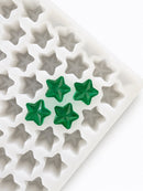 Angled view of a 4mL star gummy mold with 168 cavities and emerald green star gummies
